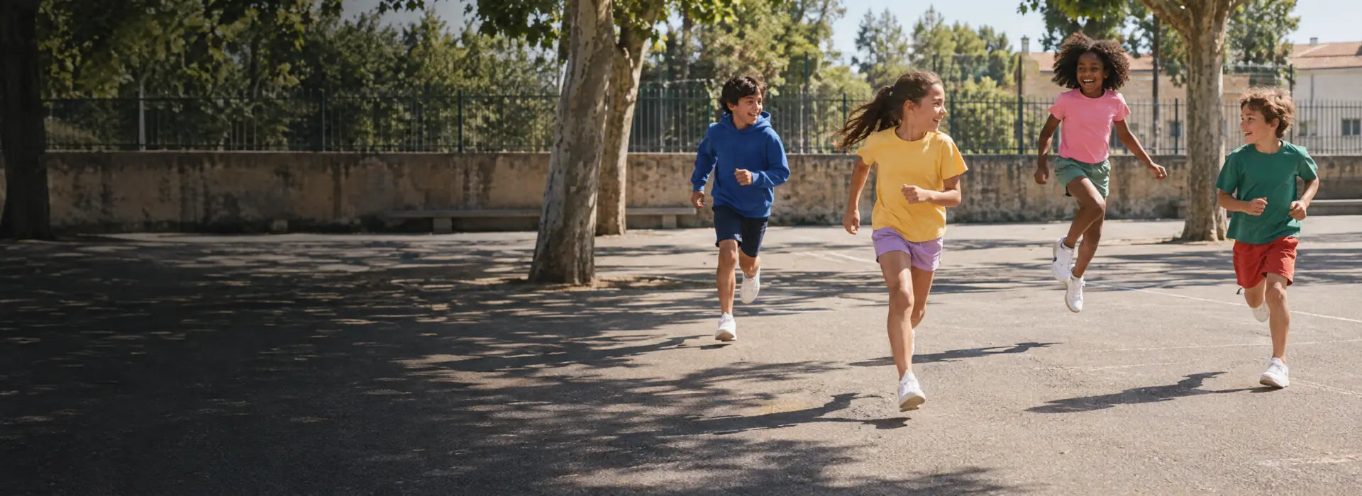 Quatre enfants qui courent dans une cour