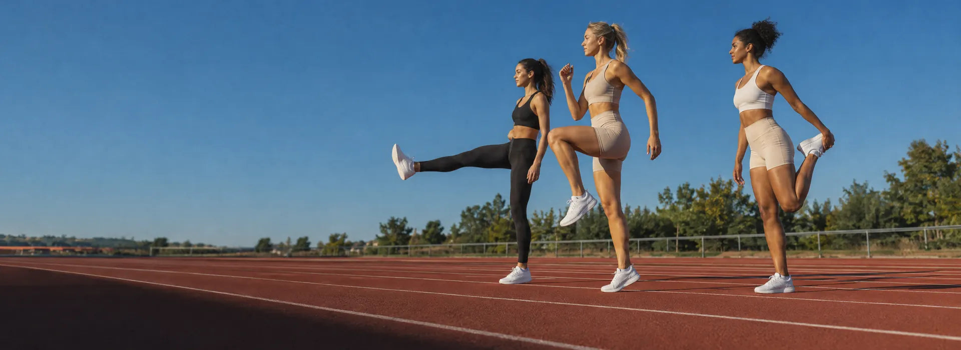 Trois athlètes à l’échauffement sur une piste d’athlétisme